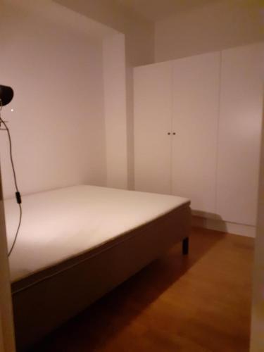 a small bedroom with a bed and white cabinets at Two room Apartment in Sundbyberg Stockholm in Sundbyberg