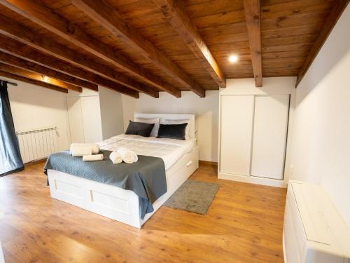 um quarto com uma cama e um tecto de madeira em Quinta Lourena - Casa do Desassossego na Covilhã