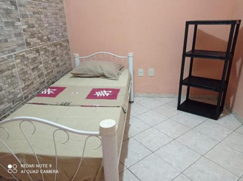 um pequeno quarto com uma cama e uma prateleira em Brazil Inn Hostel em Salvador