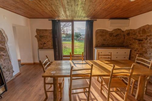 a dining room with a wooden table and chairs at Quinta Lourena - Casa do Desassossego in Covilhã