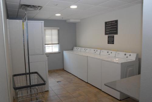 a kitchen with white cabinets and a counter and a refrigerator at Candlewood Suites Tallahassee, an IHG Hotel in Tallahassee