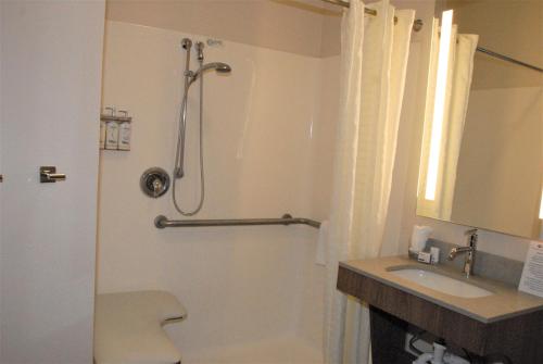 a bathroom with a shower and a toilet and a sink at Candlewood Suites Tallahassee by IHG in Tallahassee