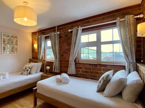 a bedroom with two beds and a window at Dabinett in Ledbury