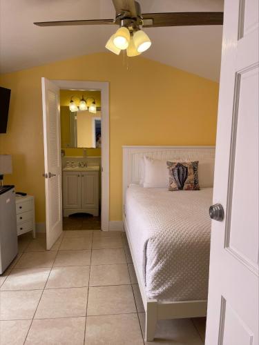 a bedroom with a bed and a ceiling fan at The Palms Hotel in Key West
