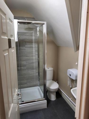 a small bathroom with a shower and a toilet at The Avenue Hotel in Grantham