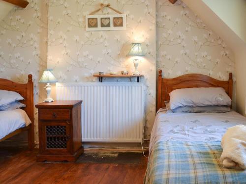 a bedroom with two twin beds and a radiator at Y Bwthyn in Llandegai