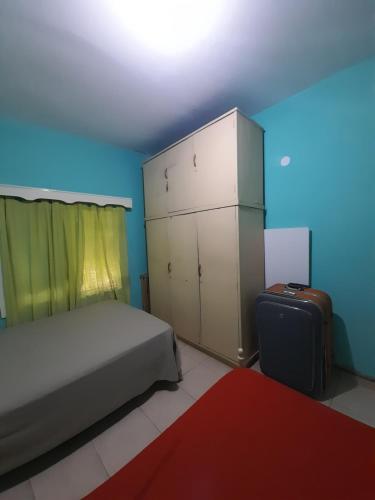 1 dormitorio con 1 cama, armario y alfombra roja en Casa ana en Ezeiza
