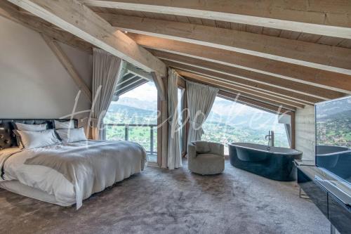 une chambre avec un lit, une baignoire et une fenêtre dans l'établissement Chalet Mage, à Combloux