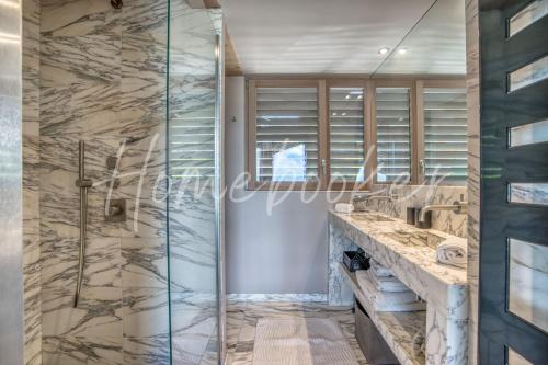 La salle de bains est pourvue d'une cabine de douche en verre. dans l'établissement Chalet Mage, à Combloux