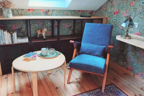 uma cadeira azul e uma mesa num quarto em La Maison de Sylvie, chambres d'hôtes à Tarbes em Tarbes