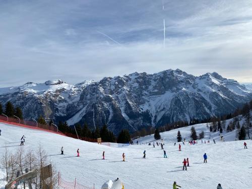 a group of people skiing down a snow covered mountain at Residence I LAMPONI incantevole trilocale casa vacanze 6 posti letto in Dimaro