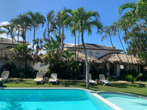 um resort com piscina e palmeiras em Hotel La Tortuga em Las Terrenas