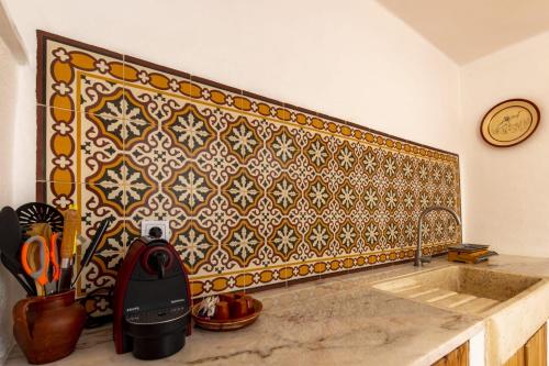 a kitchen with a sink and a tile wall at Casa do Corticeiro in Arraiolos