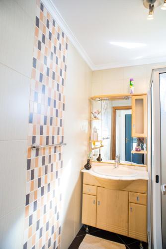 a bathroom with a sink and a mirror at Casa da Caixeira in Arco da Calheta