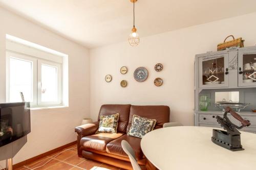 a living room with a table and a couch at Casa do Corticeiro in Arraiolos
