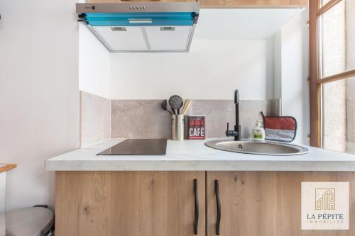 - une cuisine avec un évier et un miroir dans l'établissement Residence Bastin, à Valenciennes