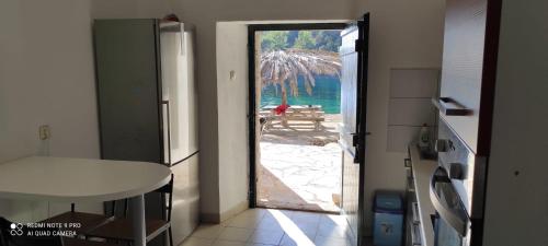 an open door to a kitchen with a view of the ocean at House on the sea Mili in Bogomolje