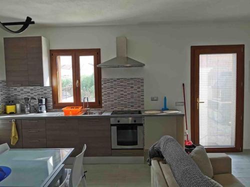 cocina con mesa y fogones horno superior en Apartment - Il Paradiso - where dreams come true, en Valledoria