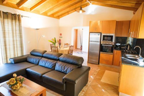 un soggiorno con divano e cucina di Casa da Caixeira ad Arco da Calheta