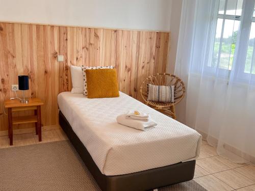 a bedroom with a bed with two towels on it at Herdade da Vagem in Rogil