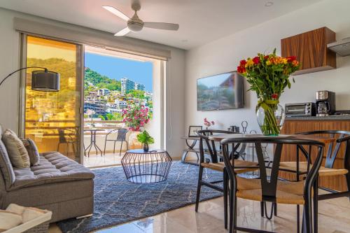 a living room with a table with a vase of flowers at Tres Marias Luxury Suites - Adults Only in Puerto Vallarta