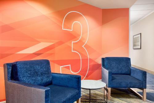 two blue chairs in a waiting room with a geometric wall at Holiday Inn Express Vancouver-Metrotown (Burnaby) in Burnaby