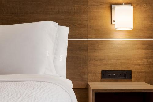 a bedroom with a bed and a light on a wall at Holiday Inn Express Vancouver-Metrotown (Burnaby) in Burnaby