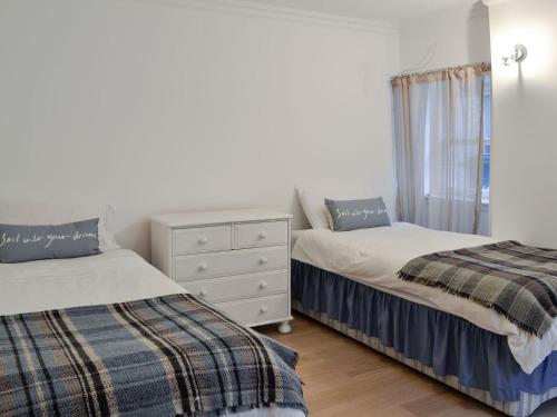 a bedroom with two beds and a dresser and a window at Jebel in Cullen