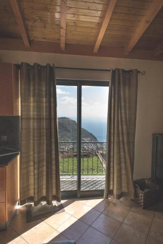 una cucina con una grande finestra con vista sull'oceano di Casa da Caixeira ad Arco da Calheta