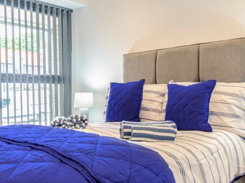 a bedroom with a large bed with blue pillows at Uk40240-the Bluebell in Scalby