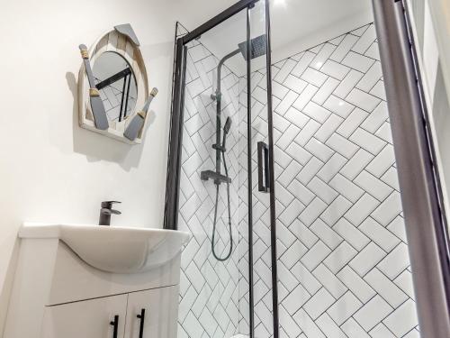 a bathroom with a shower with a sink and a mirror at Uk40240-the Bluebell in Scalby