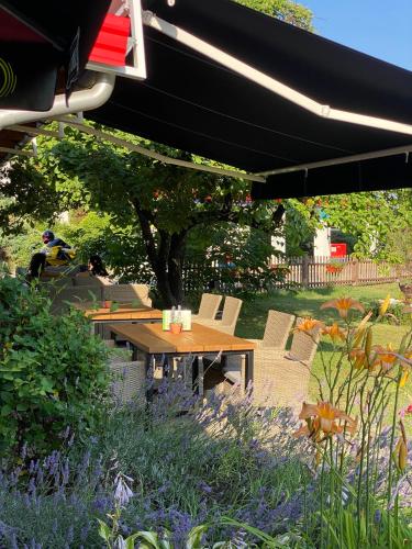 a wooden table and chairs under a patio umbrella at Motel M Vlasenica in Vlasenica
