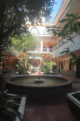 un patio con una fuente frente a un edificio en Hotel Iberia en Córdoba