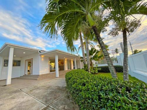 una casa blanca con palmeras delante en Zaba Beach House en San Andrés