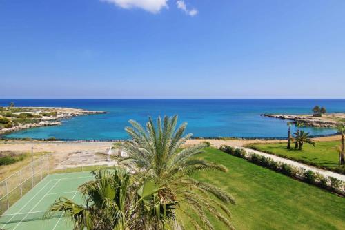 an aerial view of a tennis court and the ocean at SHARON - Coralli Beachfront Apartment in Protaras