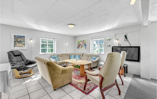a living room with a couch and a table and chairs at Pet Friendly Apartment In Strynø in Rudkøbing