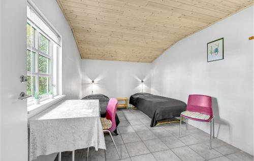 a bedroom with a bed and a table and chairs at Pet Friendly Apartment In Strynø in Rudkøbing