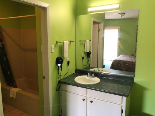 a bathroom with a sink and a mirror at Ranch House Motel Marksville in Marksville