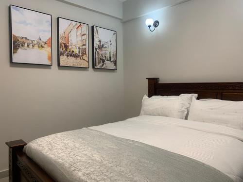a bedroom with four pictures on the wall at Diamond Luxury Suite by Diamond Homes in Nairobi