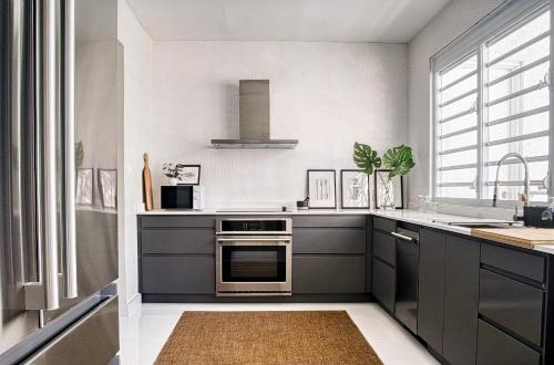 uma cozinha com armários cinzentos e um lavatório em Enjoy our Luxurious Penthouse in Condado! em San Juan