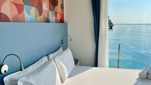 sypialnia z łóżkiem i widokiem na wodę w obiekcie Marina Uno Floating Resort w Lignano Sabbiadoro