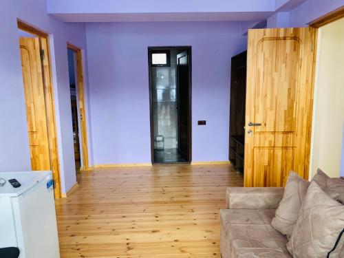 a living room with a couch and a wooden floor at House Near Forest in Bakuriani