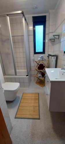 ein Bad mit einer Dusche, einem WC und einem Waschbecken in der Unterkunft To feel good: Quiet apartment, between Köln and Düsseldorf in a 3-family house in Leverkusen
