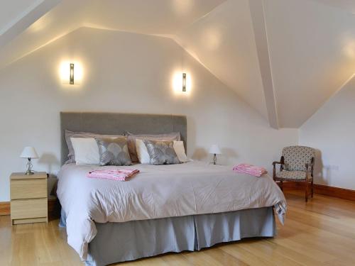 1 dormitorio con 1 cama grande y 1 silla en Three Ways, en Stroud