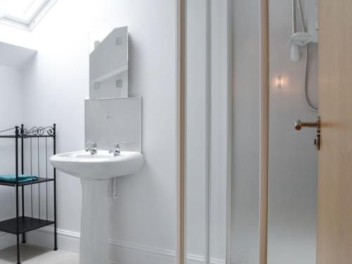 a white bathroom with a sink and a shower at Three Ways in Stroud