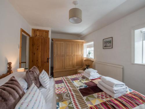 una camera da letto con un letto con cuscini sopra di Harpers Cottage a Barrowford