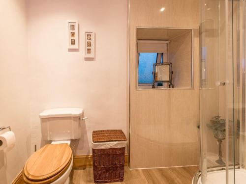 a bathroom with a toilet and a glass shower at Harpers Cottage in Barrowford