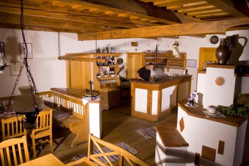 a man is sitting at a counter in a kitchen at Frühstückspension Kleinschuster in Burgau