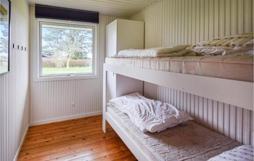 1 dormitorio con 2 literas y ventana en Liljebo en Vemmenæs