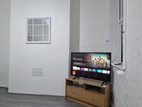 a flat screen tv sitting on top of a wooden stand at A home away from home in Birmingham